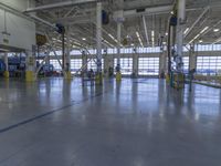 a warehouse filled with lots of empty machines and a blue chair in the middle of the room