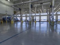 a warehouse filled with lots of empty machines and a blue chair in the middle of the room