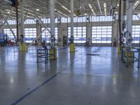 a warehouse filled with lots of empty machines and a blue chair in the middle of the room