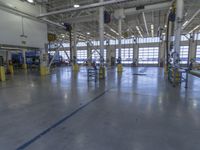 a warehouse filled with lots of empty machines and a blue chair in the middle of the room
