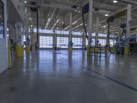 a warehouse filled with lots of empty machines and a blue chair in the middle of the room