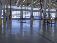 a warehouse filled with lots of empty machines and a blue chair in the middle of the room