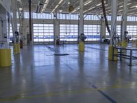 a warehouse filled with lots of empty machines and a blue chair in the middle of the room
