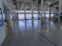 a warehouse filled with lots of empty machines and a blue chair in the middle of the room