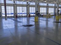 a warehouse filled with lots of empty machines and a blue chair in the middle of the room