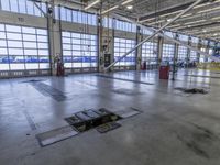 a warehouse filled with lots of empty machines and a blue chair in the middle of the room