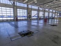 a warehouse filled with lots of empty machines and a blue chair in the middle of the room