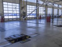 a warehouse filled with lots of empty machines and a blue chair in the middle of the room