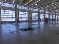 a warehouse filled with lots of empty machines and a blue chair in the middle of the room
