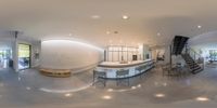 the circular photo of the interior of a house shows the curved kitchen counter and stairs