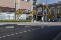 an intersection with street lights, stop lights and pedestrians at the corner of the intersection