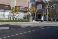 an intersection with street lights, stop lights and pedestrians at the corner of the intersection