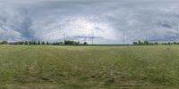 an image of the field in a panoramalated image with clouds and sun above them