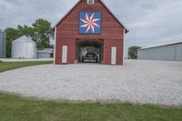 an open garage sitting in front of a barn next to two other buildings, each with one on the second floor