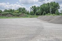 gravel that is stacked in the middle of a parking lot next to trees in the background