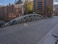 a bridge crossing a street by a city street on a cloudy day by itself, with parked bicycles underneath it