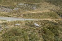 a motorcycle parked on a small mountain side road near mountains with no cars driving on it