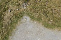 a motorcycle parked on a small mountain side road near mountains with no cars driving on it