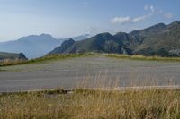 a motorcycle parked on a small mountain side road near mountains with no cars driving on it