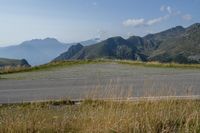 a motorcycle parked on a small mountain side road near mountains with no cars driving on it