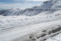 a person riding skis down a snowy slope in the mountains of a town during winter