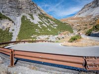 there is a curved mountain road going down it's side by side on the other side