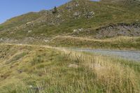 a motorcycle parked on a small mountain side road near mountains with no cars driving on it