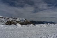 a person is standing on top of a mountain in the snow on skis and looking at the sky