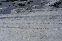 the slope is covered in white snow and has tracks in it to ski on with