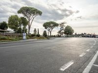 a deserted street with trees growing by the curb and buildings nearby in a neighborhood in italy