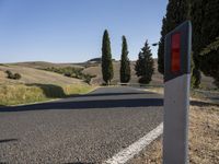 a stop light that is near the side of a road at the end of a winding road