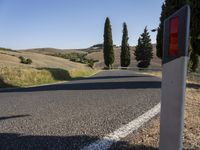 a stop light that is near the side of a road at the end of a winding road