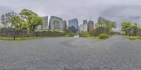 a panoramic view of some very tall buildings and a bench with a planter