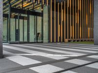 a walkway leading up to a wooden wall next to a cement area with floor tiles