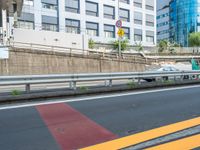 a man rides on the motorcycle down the road next to a traffic sign and some buildings