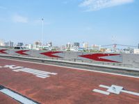 a red bike lane painted with white writing and an arrow design on it is next to the highway