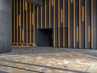 a walkway leading up to a wooden wall next to a cement area with floor tiles