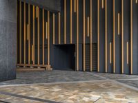 a walkway leading up to a wooden wall next to a cement area with floor tiles