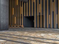 a walkway leading up to a wooden wall next to a cement area with floor tiles