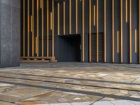 a walkway leading up to a wooden wall next to a cement area with floor tiles