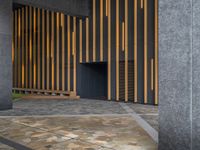 a walkway leading up to a wooden wall next to a cement area with floor tiles