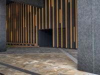 a walkway leading up to a wooden wall next to a cement area with floor tiles