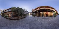 360 - vision photograph of a japanese courtyard area and a shop in the background with trees