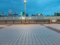 people standing on a subway platform with many buildings in the background at night light in tokyo