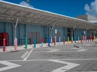 this parking lot contains some colorful and painted poles for pedestrians to cross the street through