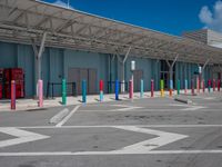 this parking lot contains some colorful and painted poles for pedestrians to cross the street through