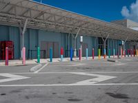 this parking lot contains some colorful and painted poles for pedestrians to cross the street through