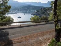 the road in the middle of the road next to the river and mountains of the sea and trees