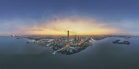 a bird - eye view of the sun setting on a city across a lake in the distance