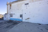 an old abandoned building with blue paint on it's walls and brick floors with rust on it